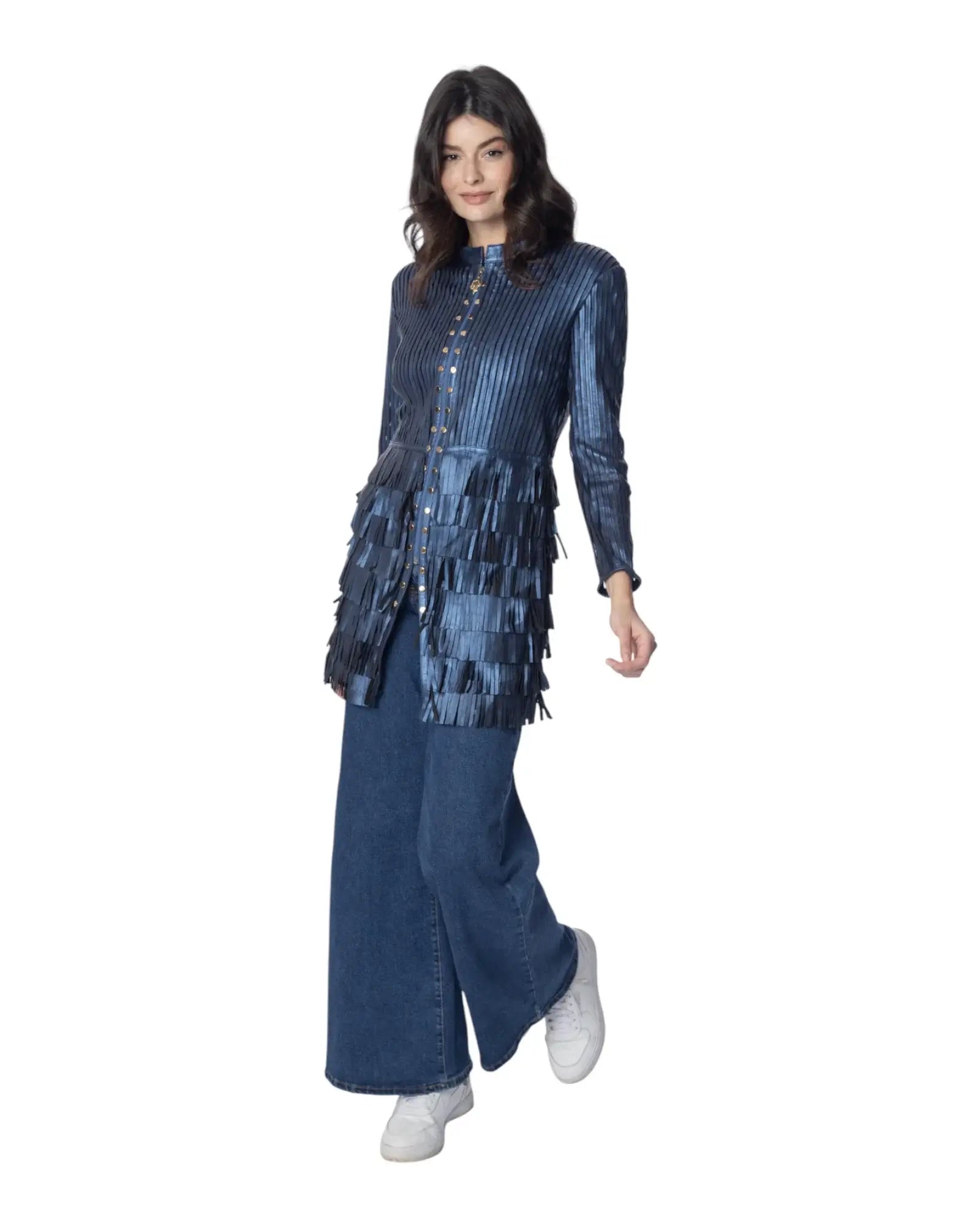 TRUDY giacca in pelle blu con frange, lunga sopra il ginocchio, abbinata a pantaloni larghi e sneakers bianche.