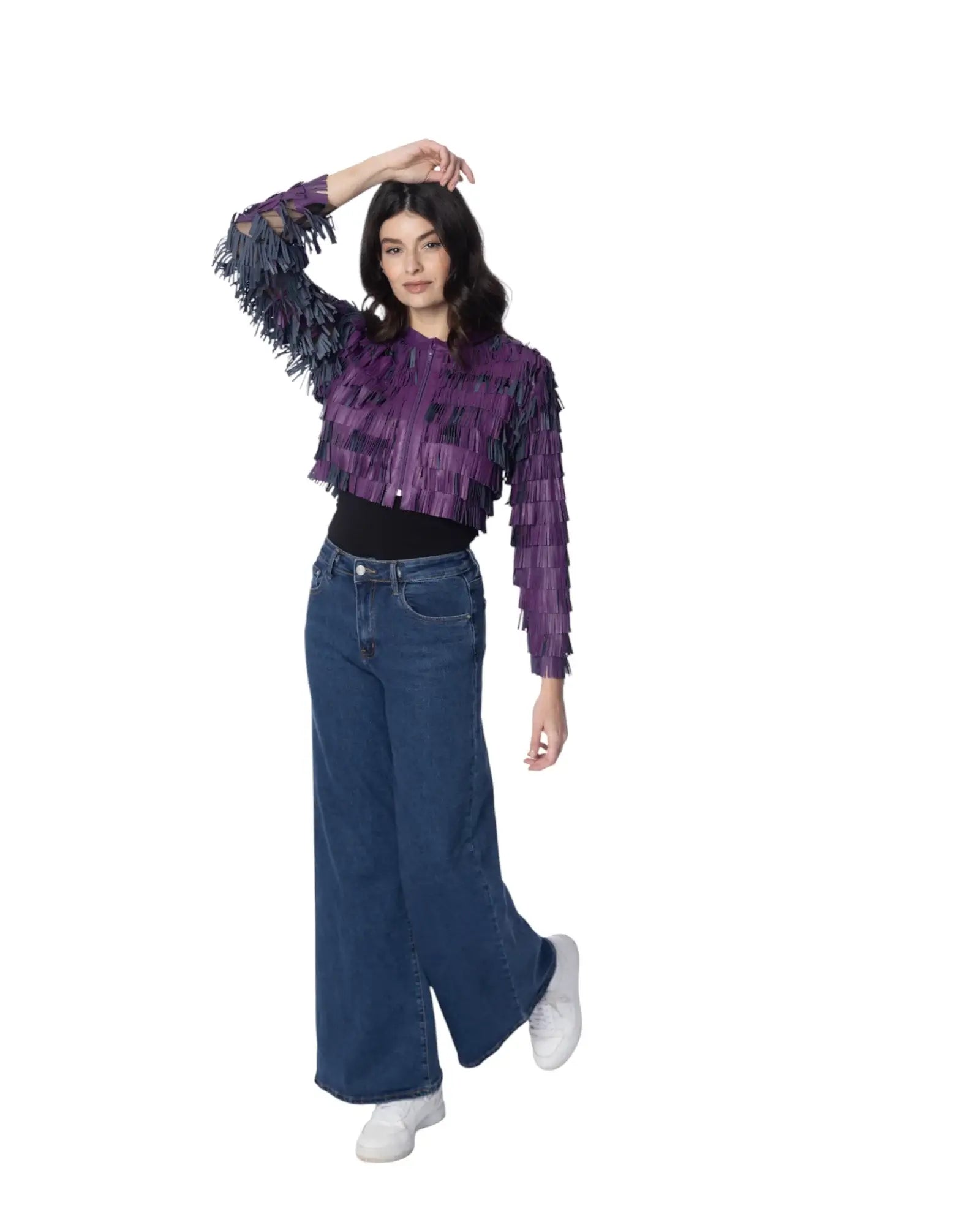 Modella che indossa la giacca DAISY in pelle con frange colorate, abbinata a jeans larghi e scarpe bianche.