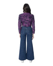 DAISY giacca corta in pelle con frange su tulle morbido, vista posteriore con pantaloni larghi in denim.