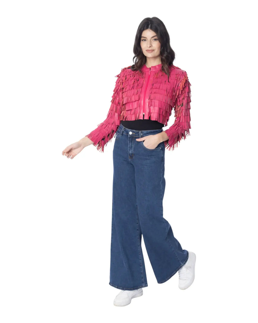 Modella che indossa la giacca DAISY in pelle rosa con frange, abbinata a jeans larghi e sneakers bianche.