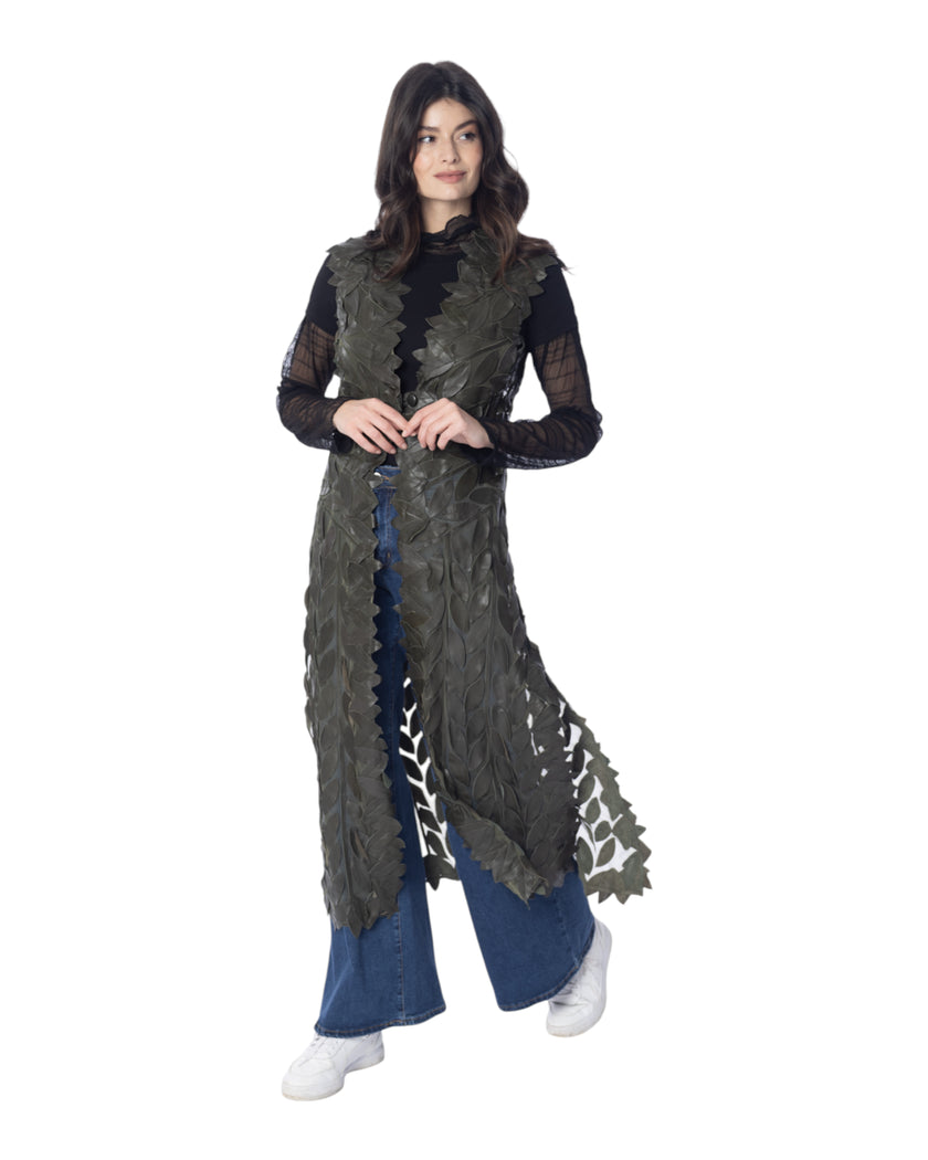 Modella che indossa il gilet lungo in pelle GINEVRA con dettaglio in foglie, abbinato a pantaloni blu e maglia nera.