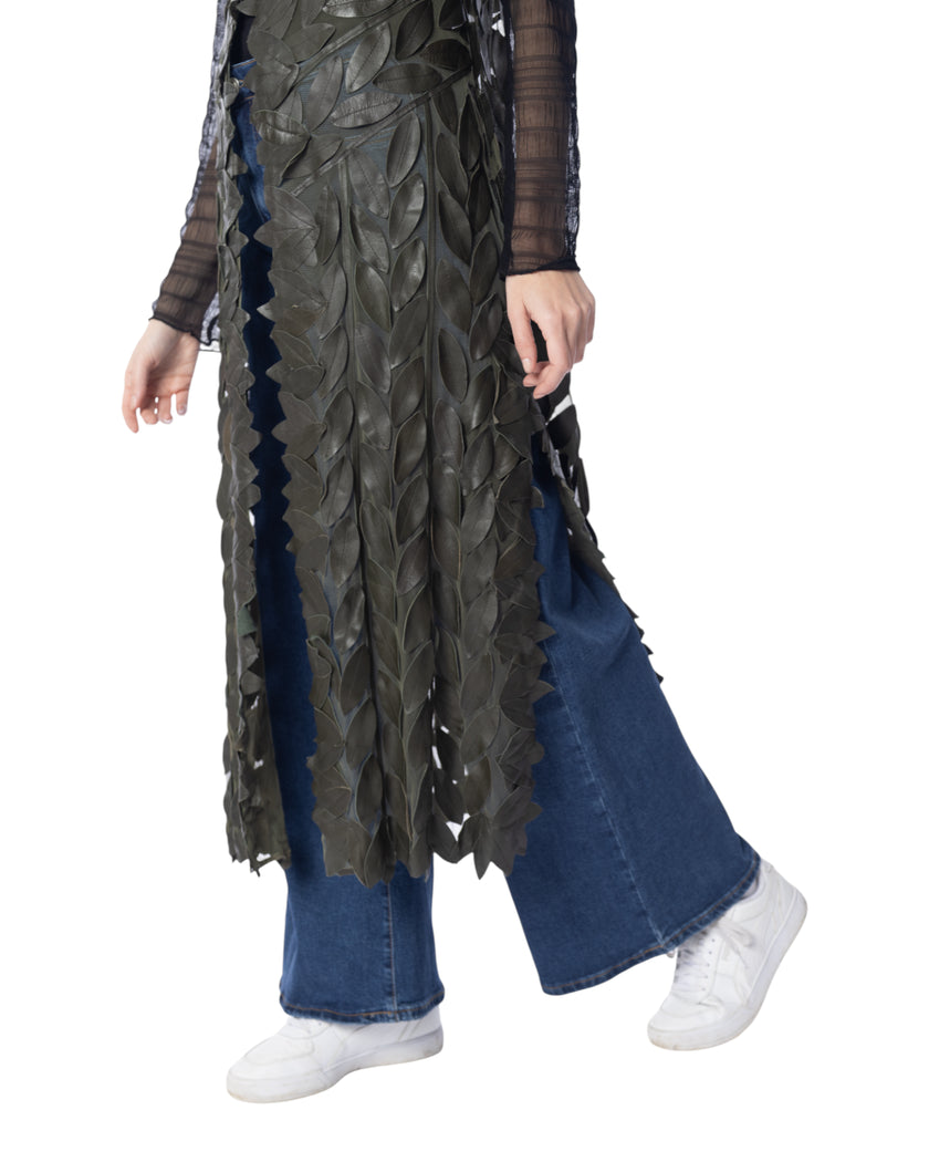Modella che indossa il gilet lungo GINEVRA in vera pelle con foglie e tulle leggero, abbinato a jeans e sneakers bianche.